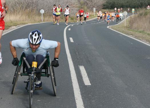Un atleta en silla de ruedas sobre el asfalto